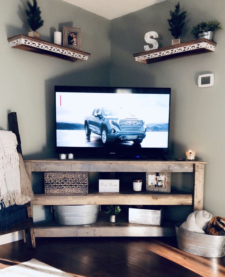 a flat screen tv sitting on top of a wooden entertainment center in a living room