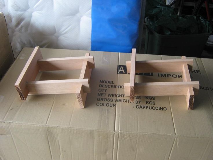 two wooden trays sitting on top of a cardboard box next to eachother