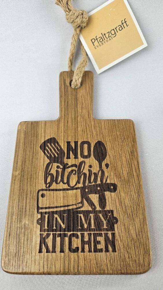 a wooden cutting board with a sign that says no bitchin'n in my kitchen