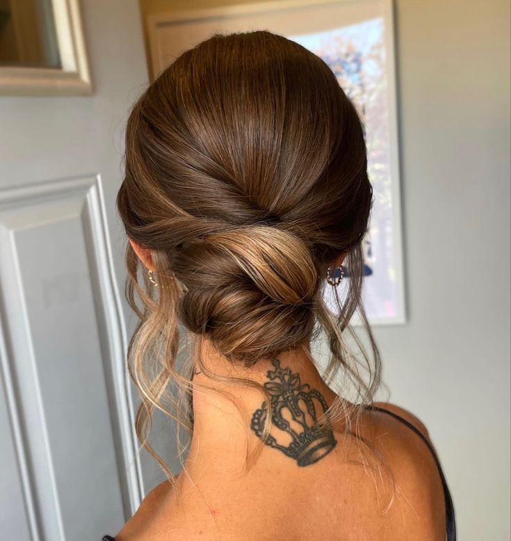 the back of a woman's head with a tattoo on her upper arm and shoulder