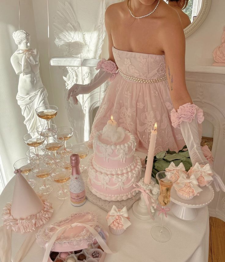 a woman in a pink dress standing next to a cake