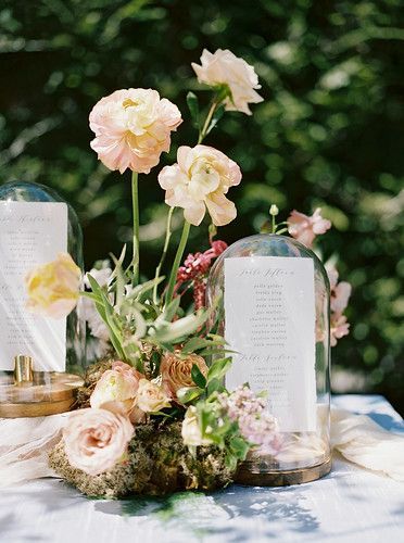 an arrangement of flowers in glass vases on a table