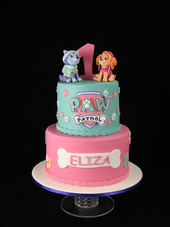 a pink and blue cake with paw patrol on top