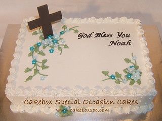 a cake decorated with blue flowers and a cross on top that says god bless you noaf