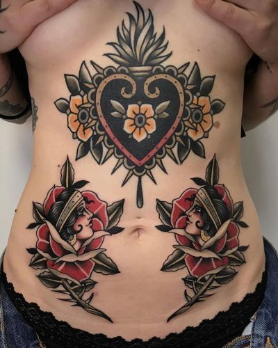 a woman's stomach with tattoos on it and flowers in the shape of a heart