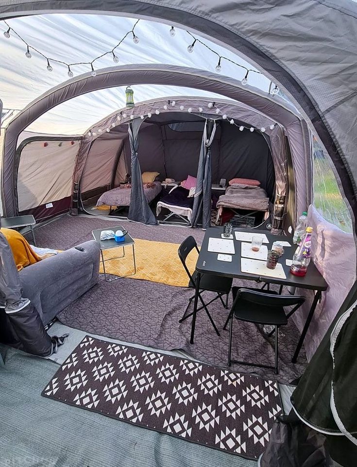 the inside of a tent with tables, chairs and couches in it is shown