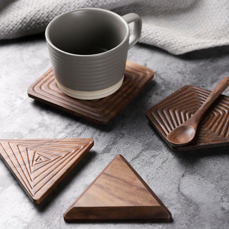 four wooden coasters and a cup on a table