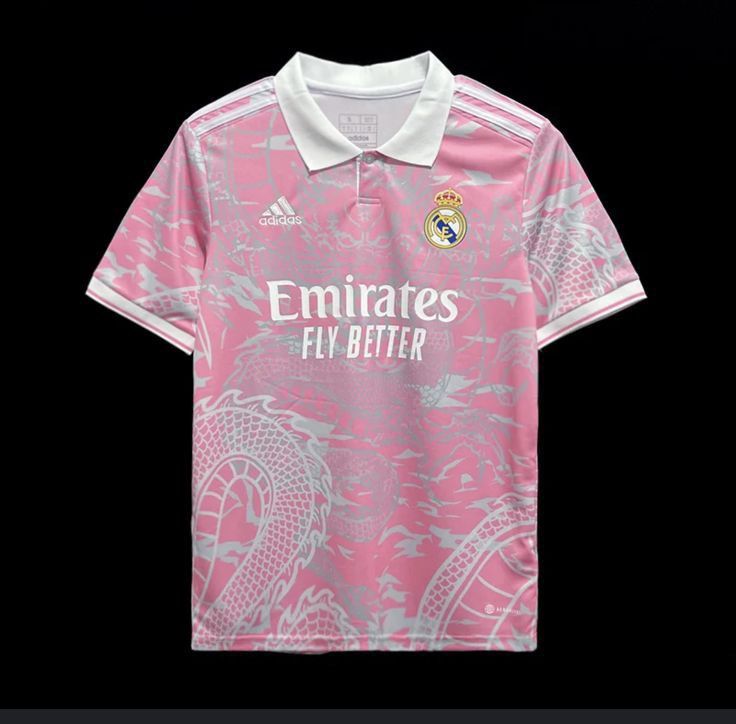 the real madrid jersey is shown in pink and white, with an emblem on it