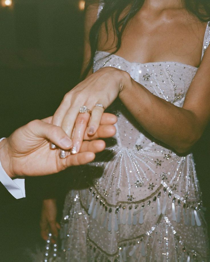 a man and woman holding hands while standing next to each other on a dance floor