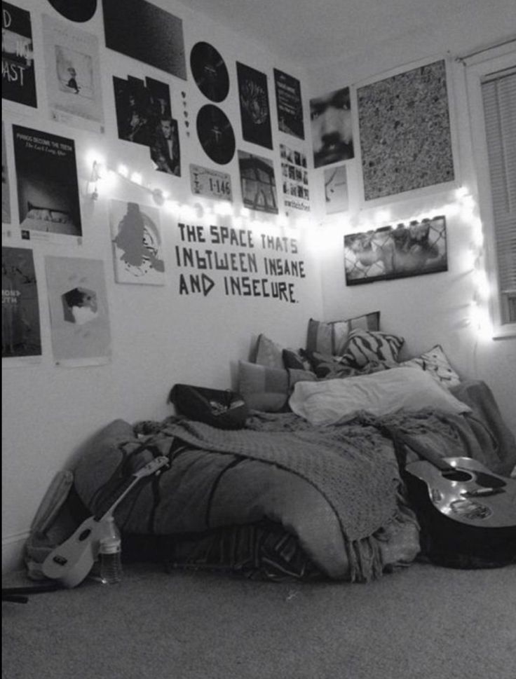 black and white photograph of a bedroom with guitars on the wall