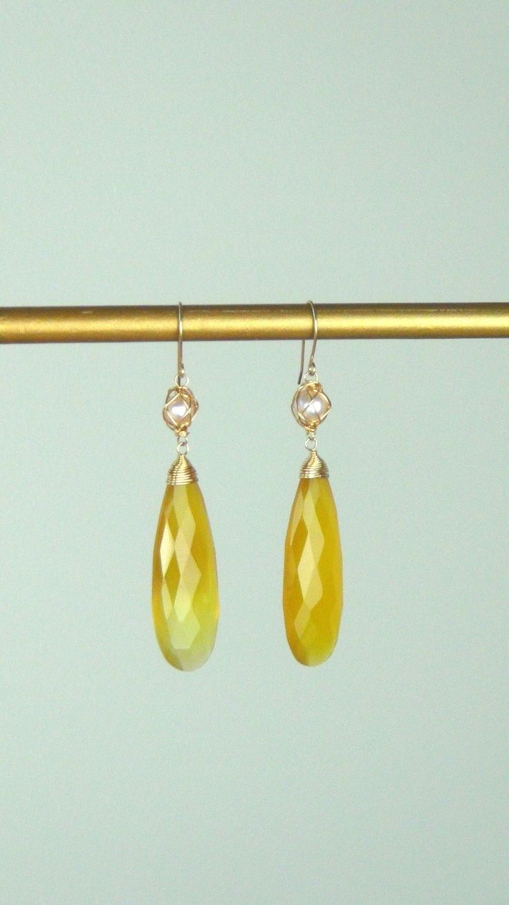 "CITRINE DROP EARRINGS WITH FRESH WATER PEARLS IN 14K GOLD Beautiful pair of faceted Citrine drops, wrapped in 14K gold wire topped off by wrapped white freshwater pearls.  So Glamorous! The citrines catch the light and sparkle brilliantly.  They are a beautiful yellow.  All gold and gemstones are 100% authentic.  They are high quality and super stylish. The earrings measure 2 1/2\" long, and the citrines are about 1 1/2\" by 1/2\" wide.  They are wrapped expertly with 14K gold wire.  The freshwater pearls have a criss cross netting of 14K gold. A beautiful addition to an elegant occasion." Faceted Drop Yellow Gold Jewelry, Faceted Yellow Gold Drop Jewelry, Fine Jewelry Drop Earrings With High Luster, High Luster Briolette Gold Jewelry, Teardrop Gemstone Earrings In Yellow Gold, Gold Drop Jewelry With High Luster, High Luster Yellow Jewelry For Weddings, 14k Gold Drop Earrings With Faceted Detail, Elegant Yellow Long Drop Jewelry