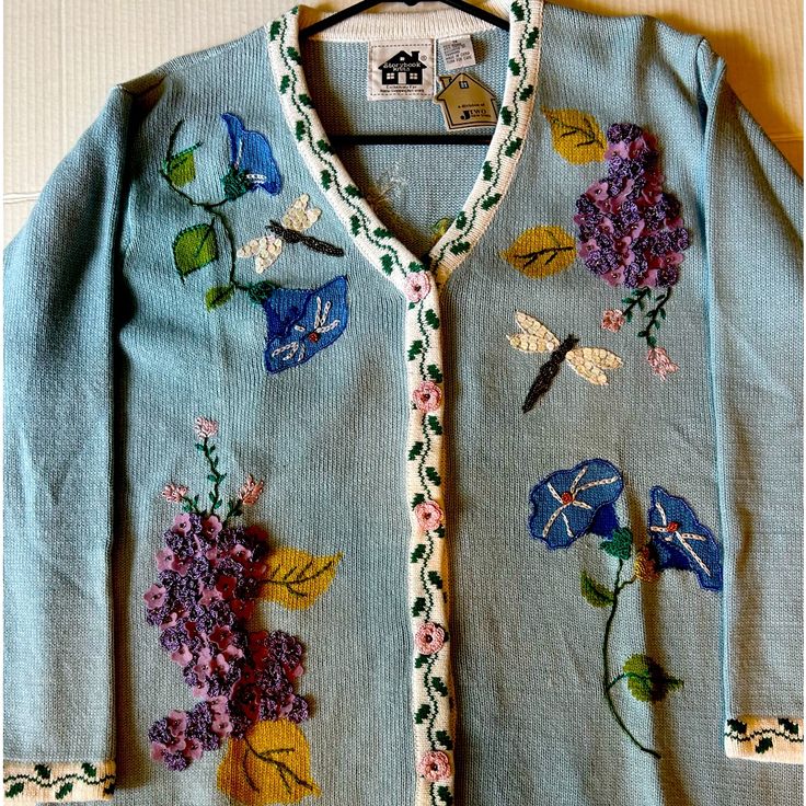 a blue sweater with flowers and butterflies on it