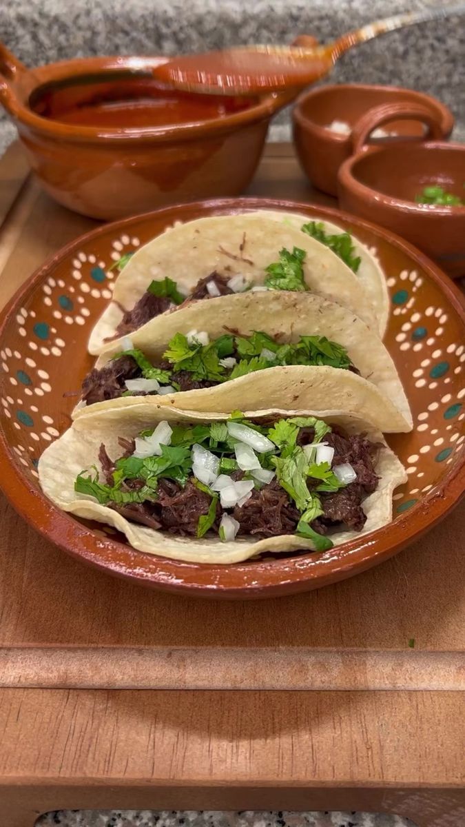 two tacos are sitting on a brown plate