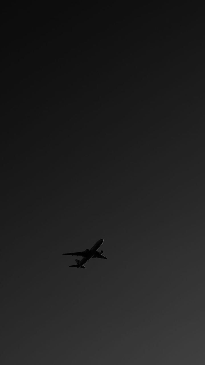 an airplane is flying in the dark sky