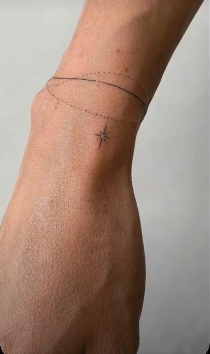 a person's arm with a small star tattoo on the left side of their arm