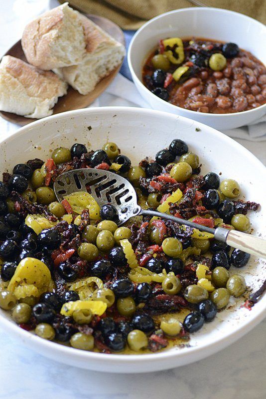 two bowls filled with olives and bread