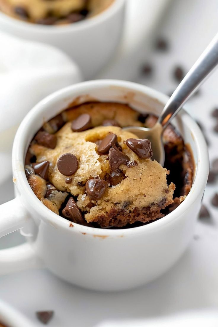 two mugs filled with chocolate chip cookies and ice cream