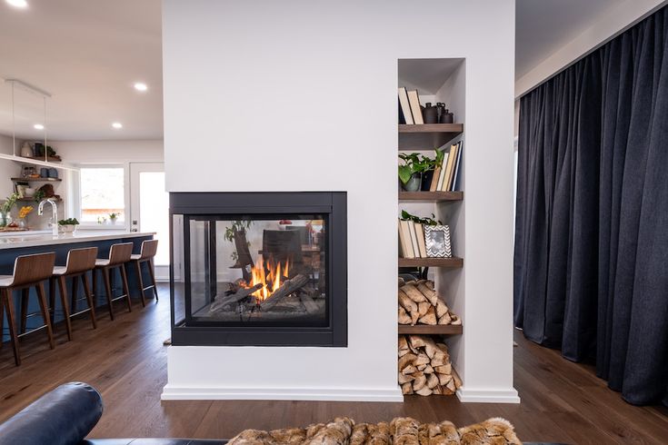 a living room filled with furniture and a fire place next to a kitchen counter top