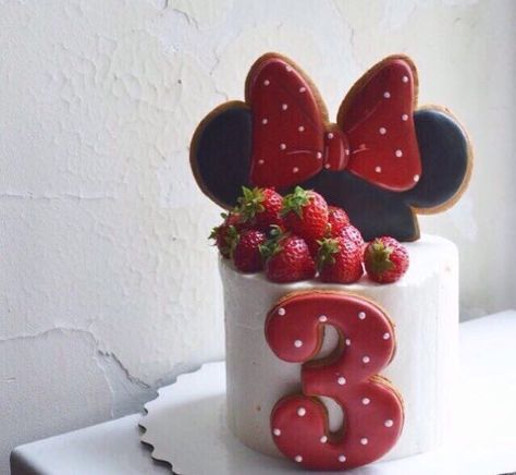 a birthday cake with strawberries and mickey mouse ears on top is decorated to look like the number three