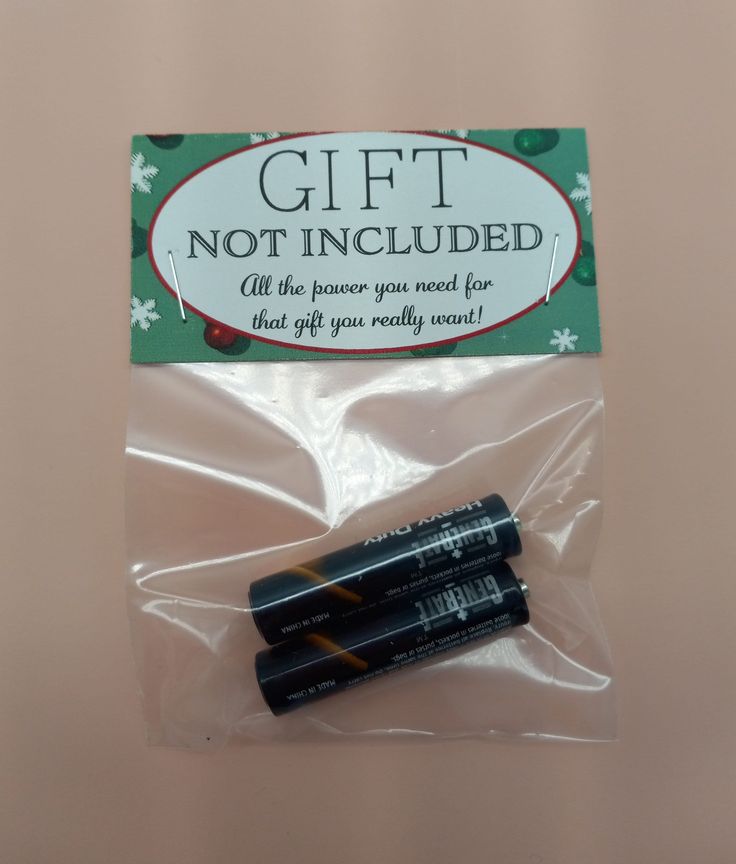 two batteries in plastic wrap on top of a pink surface with the words gift not included