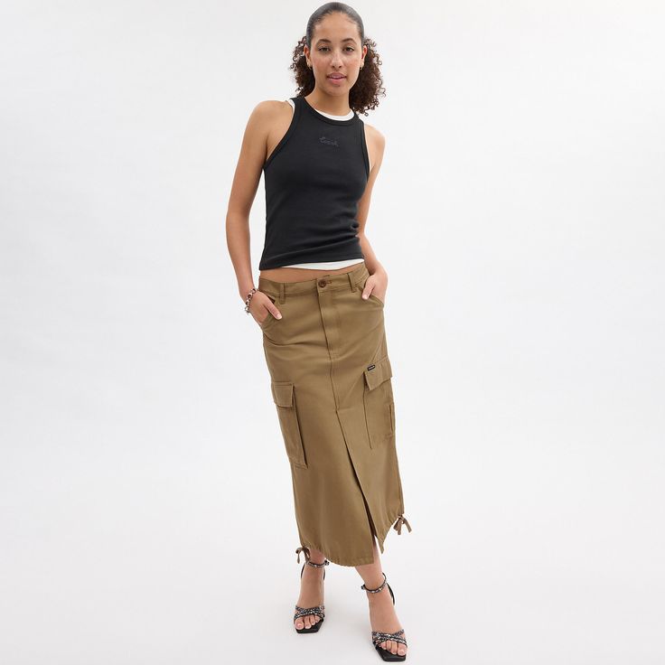 A ‘90s-inspired take on vintage utilitarian styles this maxi cargo skirt is designed with traditional workwear pockets to hold your on-the-go essentials. Crafted of organic cotton made without the use of harmful chemical fertilizers and pesticides the long silhouette is finished with a front vent for added mobility and tie details at the hem. Utility Cotton Cargo Skirt, Utility Cotton Skirt For Fall, Fall Utility Cotton Skirt, Fall Cotton Skirt With Cargo Pockets, Utility Cotton Cargo Skirt For Fall, Spring Cotton Cargo Skirt With Multiple Pockets, Fall Utility Cotton Cargo Skirt, Utility Cotton Skirt With Side Pockets, Utility Style Long Skirt With Cargo Pockets