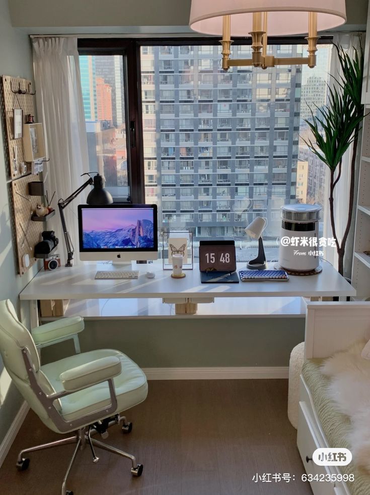 a desk with a computer and chair in front of a large window overlooking the city