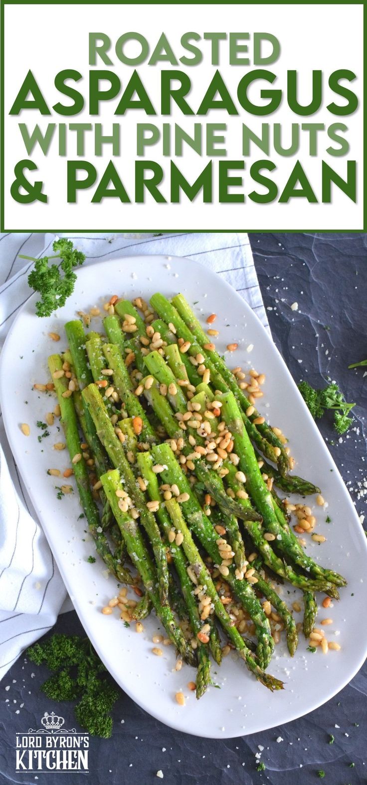 roasted asparagus with pine nuts and parmesan on a white platter