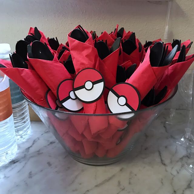 a bowl filled with red paper flowers on top of a counter