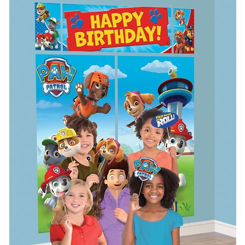 two girls standing next to each other in front of a happy birthday sign with paw patrol characters on it