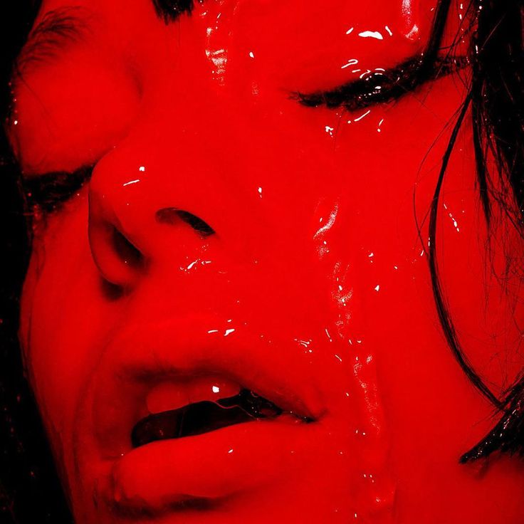 a woman with her face covered in red liquid