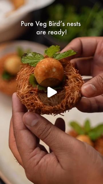 a person holding a tiny bird nest with food in it's hands and the words pure veg bird's nests are ready