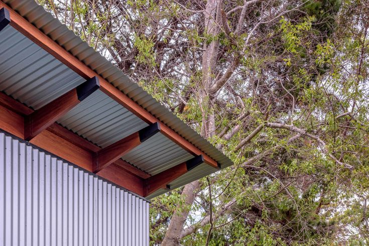 the roof of a building with metal siding and wood shingles on it's sides