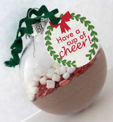 a glass ornament filled with candy on top of a white tablecloth covered surface