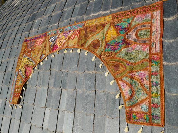 an arch on the side of a building decorated with colorful designs and tassels