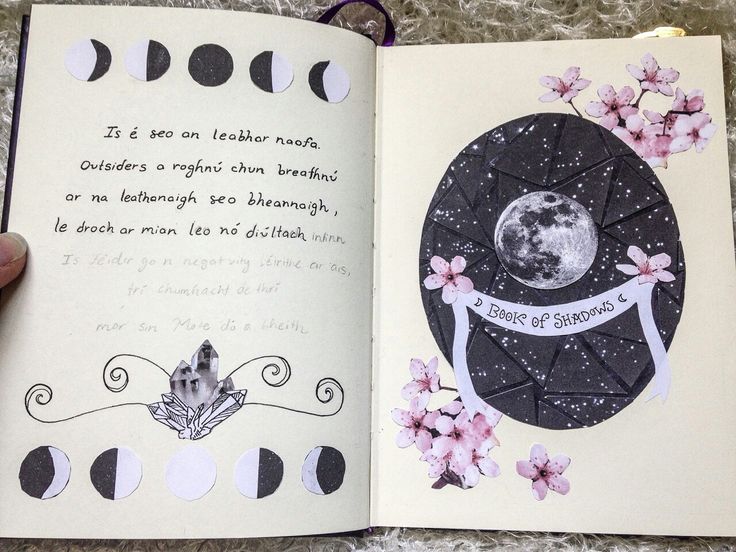 an open book with paper cut outs and writing on it, in the shape of a moon