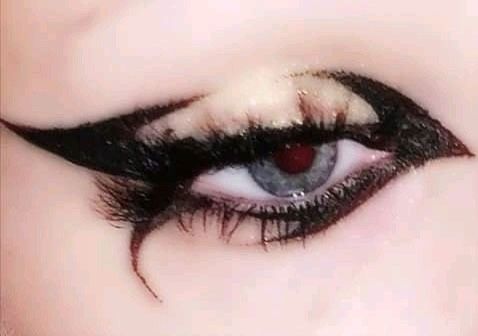 an eye with black and white makeup looks like it is in the middle of someone's eyes