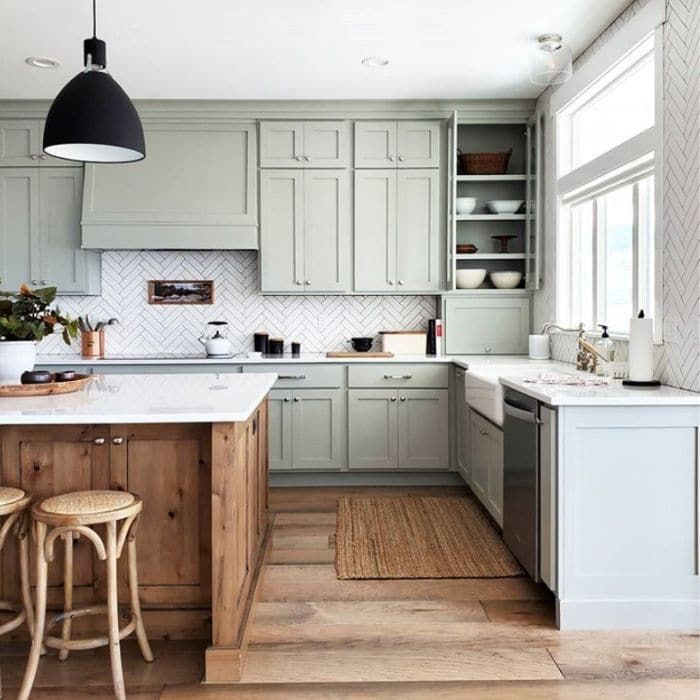 a kitchen with white cabinets and wooden floors