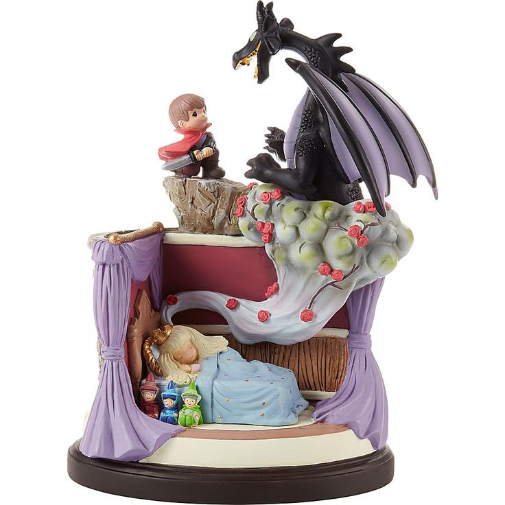 a figurine of a dragon sitting on top of a bed next to a child