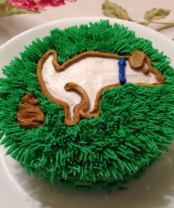 the cake is decorated with green grass and blue icing, including an image of a dog