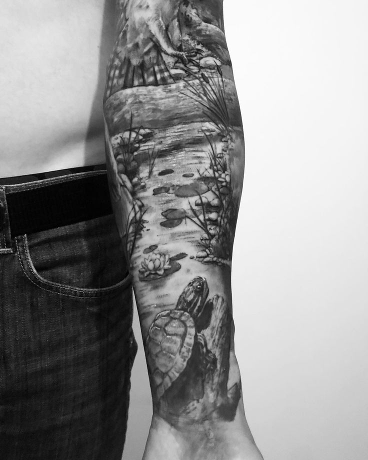 a man's arm with an eagle and water scene tattoo on his left arm