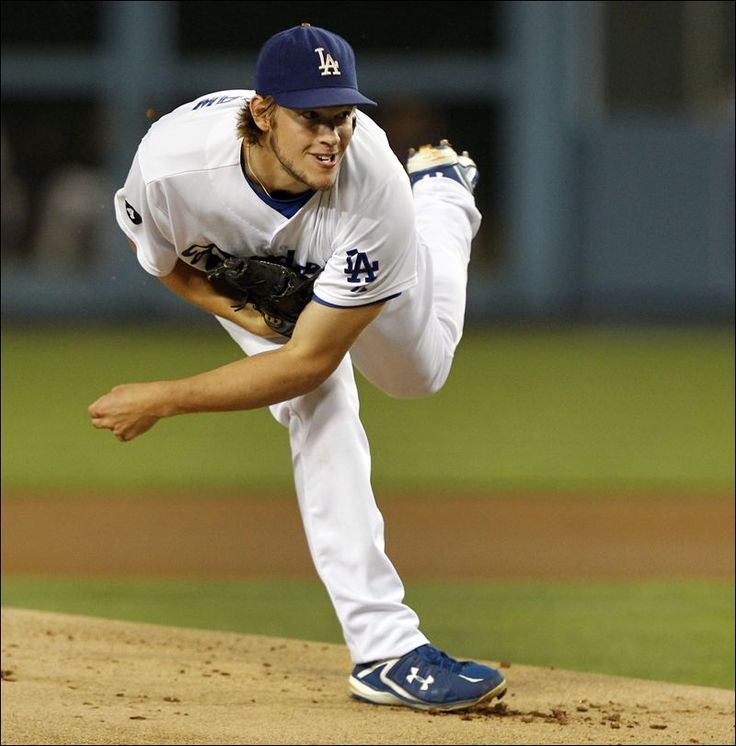 a baseball player pitching a ball on top of a field