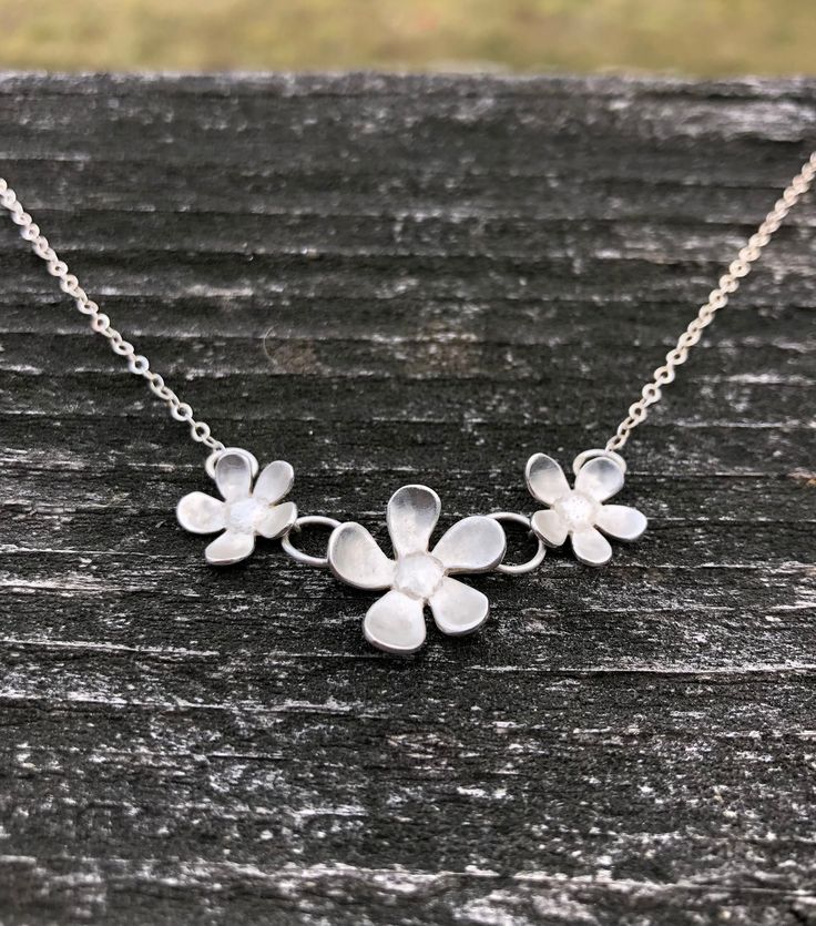 Beautiful, elegant, and whimsical. This silver flower necklace is sure to be a hit! Three darling flowers dance on a delicate yet strong fine silver chain in a length of your choice and secured with a silver lobster clasp. The flowers measure 2 inches across and 7/8 inch tall in the middle. Delicate Sterling Silver Jewelry With 3d Flowers, Sterling Silver Jewelry With 3d Flowers, Handmade Silver Flower Necklace For Anniversary, Silver Flower Necklace For Wedding, Sterling Silver Jewelry With 3d Flower Design, Silver Jewelry With Handmade Flowers As A Gift, Silver Jewelry With Flower Decoration For Gift, Silver Jewelry With Handmade Flowers For Gift, Silver Delicate Flower Charm Necklace