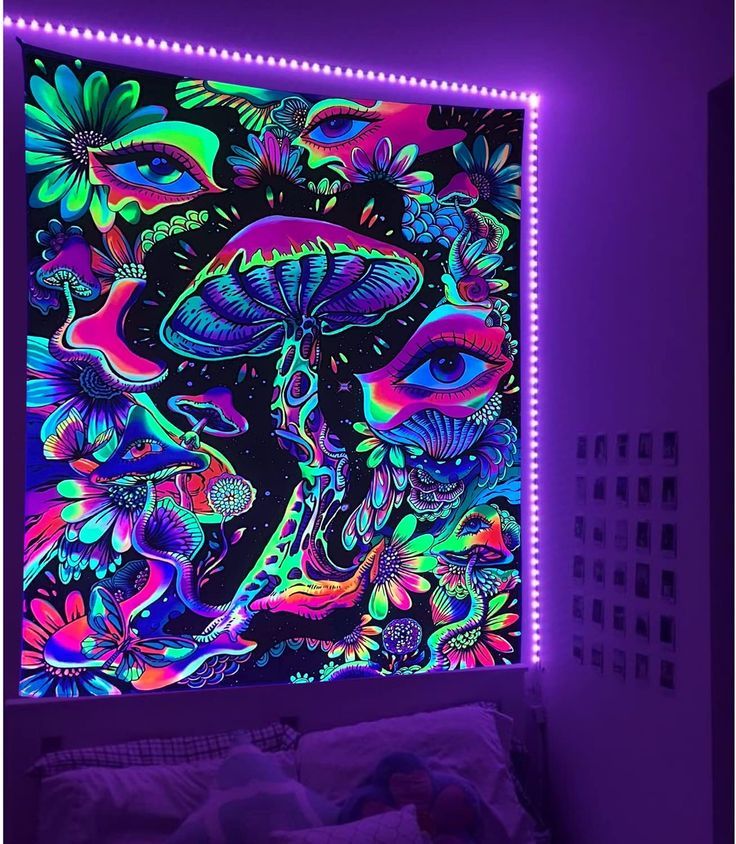 a bed room with a lit up wall and a painting on the wall above it