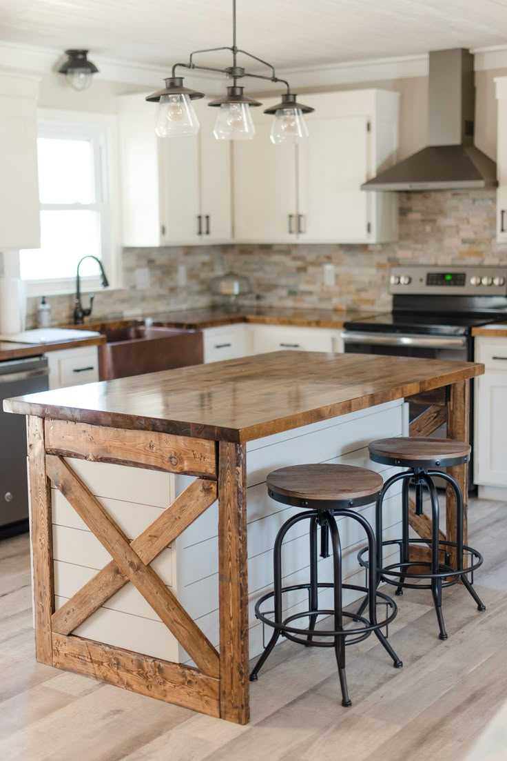 a kitchen island made out of wood with two stools in front of the island