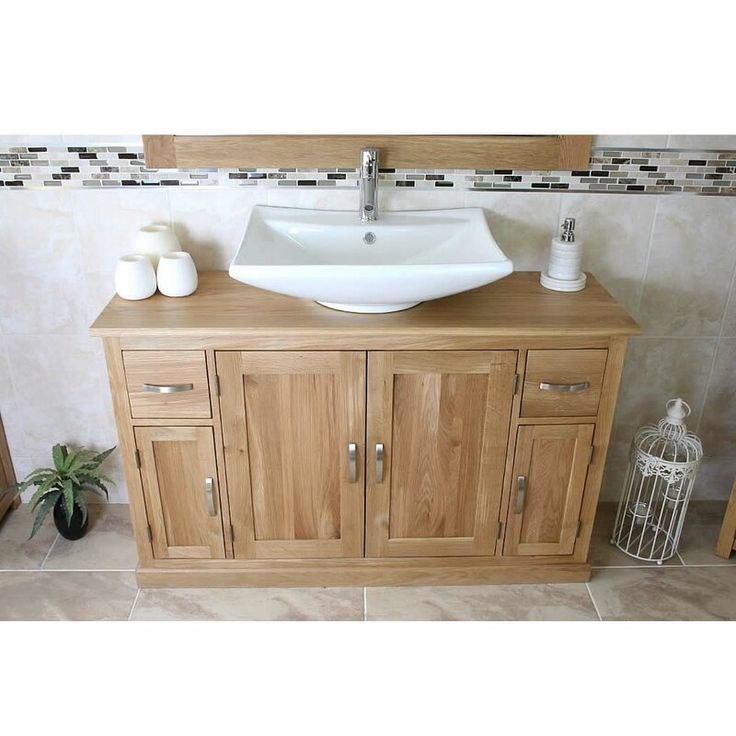 a bathroom sink sitting on top of a wooden cabinet