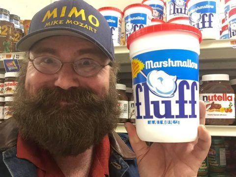 a man holding up a cup of yogurt