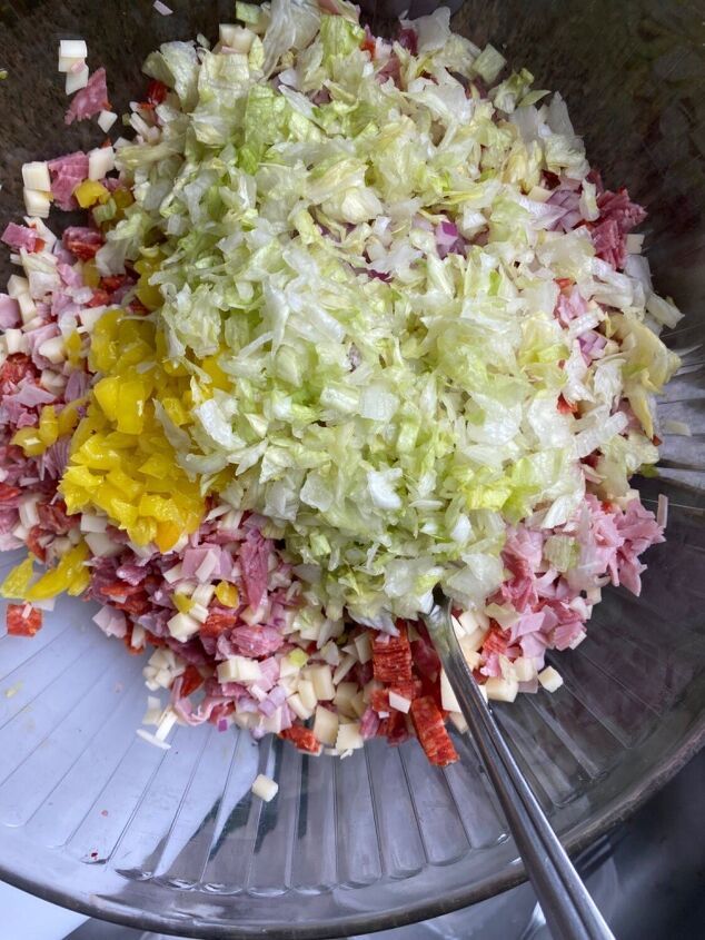 chopped vegetables are in a bowl with tongs