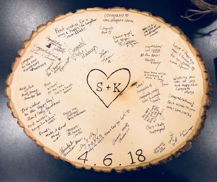 a tree slice with writing on it and a heart in the center surrounded by other words