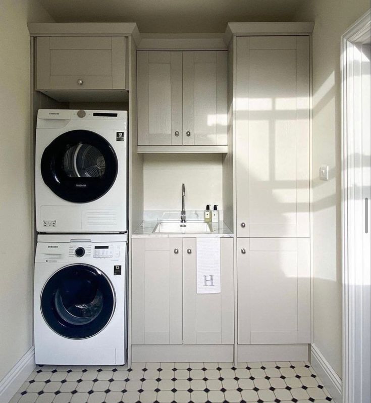 a washer and dryer sitting in a room next to each other with cabinets