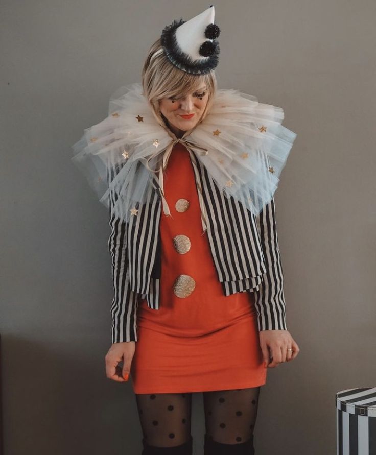 a woman dressed in an orange dress and striped jacket